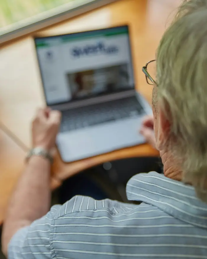An older man using a laptop at a desk